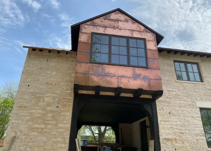 Copper metal panel facade on a stone building for Roof Repair in Bloomingdale